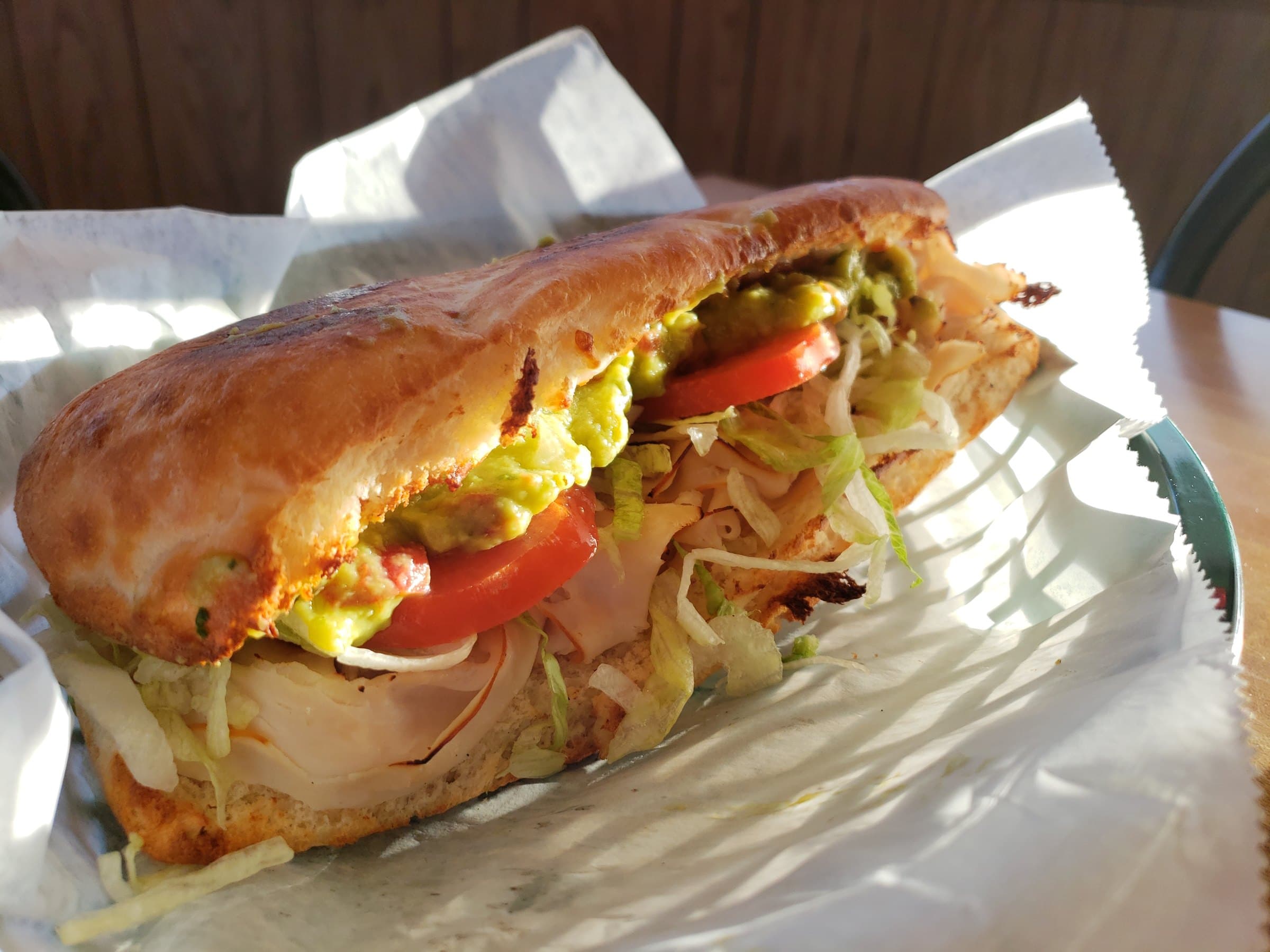 Five O' Guac Somewhere grinder with turkey, lettuce, tomato, and guacamole.